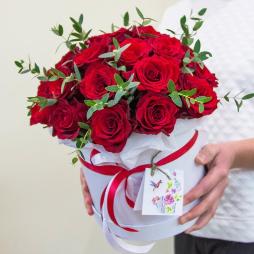 Фото Композиция в шляпной коробке из красных роз и зелени